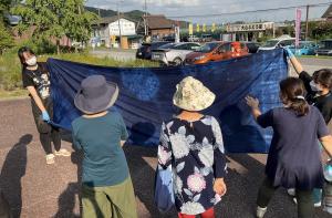 染めあがった大判の生地を見る参加者