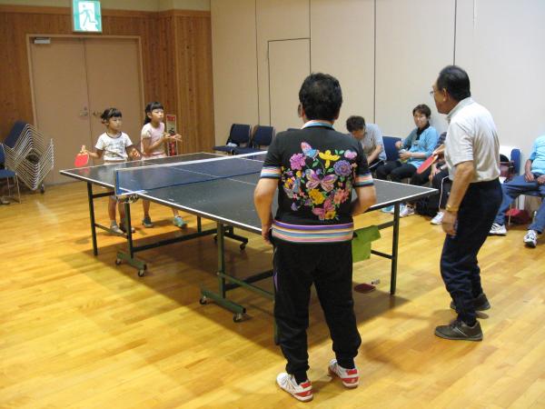 卓球をする小学生と高齢者