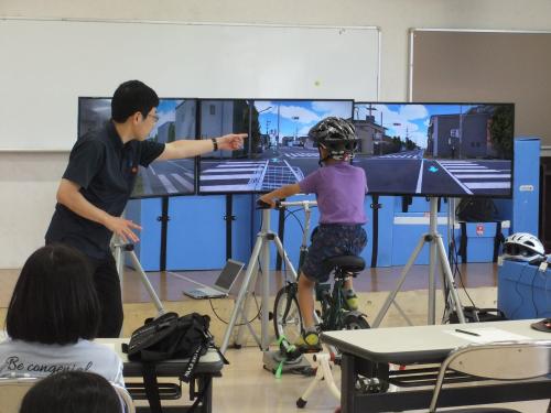 自転車のシミュレータの体験をしている様子です