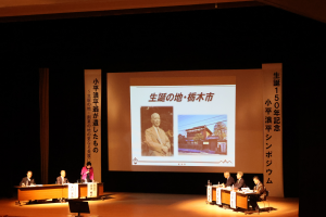 小平浪平の写真と栃木市合戦場にある生家の写真をバックに説明