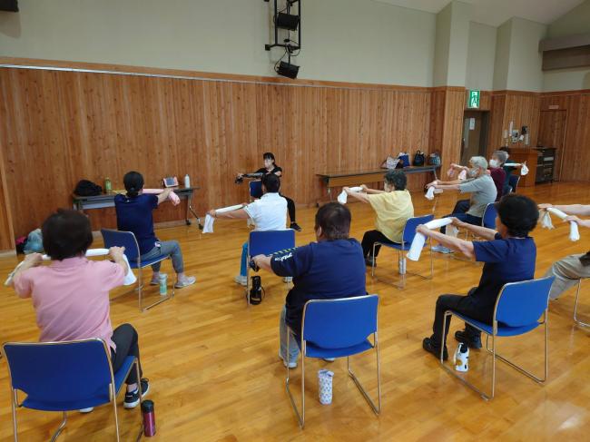 タオルを使って腕や肩のストレッチをしています