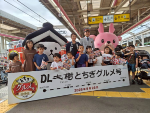 栃木駅のホームのDL機関車の前でとち介、駅長と市長、たくさんの子供たち