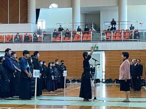 右手を高く上げ市長の前で選手宣言をする柔道着の選手