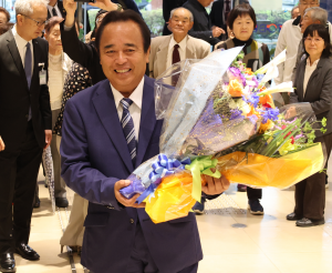 花束をもって、市民に歓迎され初登庁