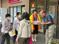 募金箱を首に下げスーパーの出入り口で募金を市民に呼びかけ