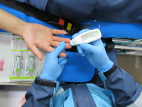 救急救命士が傷病者の血糖測定を実施している画像